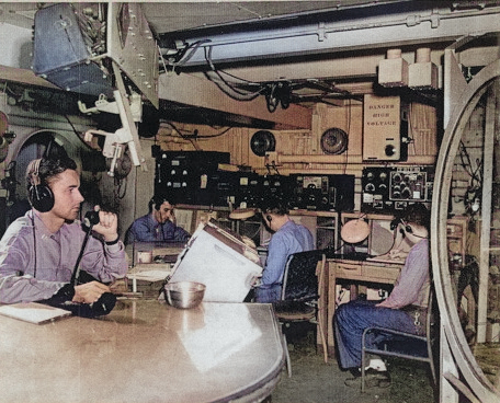 Lieutenant Charlie Wadsworth, Ray Elliott, Howard Arb, and Jack Whirson in the combat information center aboard USS Anzio while the ship was off Okinawa, Japan, 21 Apr 1945 [Colorized by WW2DB]