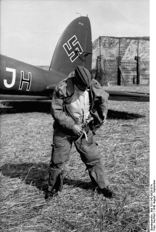 German airman putting on his gear in an airfield, France or Belgium, Aug-Sep 1944; note tail of He 111 aircraft in background
