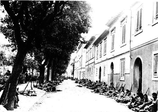 Japanese-American troops of 100th Infantry Battalion of US 442nd Regimental Combat Team resting on the side of a street in Livorno, Castellina Sector, Italy, 19 Jul 1944