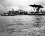 USS Oglala capsized at the 1010 Dock, Pearl Harbor, Oahu, Hawaii, Dec 8, 1941. USS Argonne is on the left beyond the dock and Floating Crane YD-25 on the right.