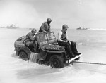 A Jeep being towed ashore at Normandy, France, Jun 12, 1944. Note that censors have deleted markings on the Jeep