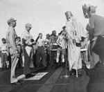 Rear Admiral Frederic Sherman, left, and Captain Carlos Wieber bid welcome to the Ruler of the Raging Main, Neptunus Rex, and his Court aboard USS Essex for the Line Crossing ceremony, 1 Sep 1944