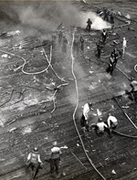 Damage control parties trying to bring fires under control on the flight deck of USS Intrepid following the crash of a Japanese special attack aircraft off the Philippines, 25 Nov 1944