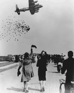 A British Lancaster bomber dropping food parcels for the starving residents of Ypenburg, Netherlands as part of Operation Manna, May 1945.