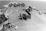 SB2C Helldivers of Bombing Squadron VB-19 on the deck of USS Lexington (Essex-class) being fitted with drop tanks for an extended mission to search for the fleeing Japanese fleet, 25 Oct 1944.