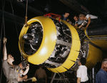 North American Aviation factory workers mounting an engine on a B-25 bomber, Inglewood, California, United States, 1942