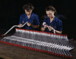 Two female employees of Vultee inspecting tubing that would later be used in Vengeance dive bombers, Nashville, Tennessee, United States, Feb 1943