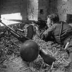 Private Jack Bailey of Canadian Perth Regiment sniping at Germans, Ortona, Italy, 29 January 1944; note Enfield Pattern 1914 rifle with telescopic sight and Bren light machine gun