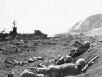 US Marines burrowing in the volcanic sand on the beach of Iwo Jima, Japan, 20 Feb 1945; note LST-264 and Mount Suribachi in background