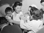 Japanese-American woman being vaccinated at the assembly center in Arcadia, California, United States, 1942