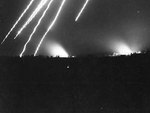Star shells in the sky and fires burning on the ground illuminated the city of Garapan at night, Saipan, Mariana Islands, Jul 1944