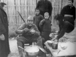 Japanese soldier dining among Chinese civilians, Nanjing, China, 15 Dec 1937