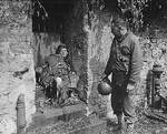 US Army Captain Earl Topley looking at a German soldier who had killed three of his men before his own death, Cherbourg, France, 27 Jun 1944