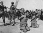 Chinese soldiers executing two Chinese men who had been found guilty of collaboration with the Japanese, China, circa late 1930s