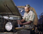 African-American mechanic in the US Army maintaining a truck, Fort Knox, Kentucky, United States, Jun 1942, photo 1 of 2