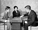 Crown Prince Akihito and Emperor Showa playing shogi, with Empress Kojun watching, Japan, Jan 1955
