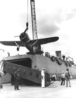 Brewster F2A-3 Buffalo being lifted aboard aircraft transport USS Kitty Hawk at Pearl Harbor, Hawaii, May 1942. Note open hangar bay in the stern of the ship.