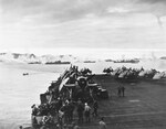 Ships in Kerama Retto anchorage near Okinawa, Japan spreading an anti-kamikaze smoke screen, 3 May 1945, as viewed from USS Sargent Bay. Note TBM Avenger and FM-2 Wildcat aircraft in foreground.