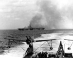 Carrier Ticonderoga burning after being struck by special attack aircraft off Taiwan, 21 Jan 1945; note light cruiser Miami