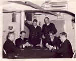 Lieutenant Harold Kelly (standing with pipe) and other officers playing cards aboard USS Wasp, date unknown