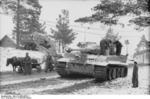 German donkey and horse carts passing by a Tiger I heavy tank in a Russian town, winter of 1943-1944