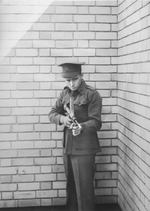 Australian Army Private Evelyn Owen posing with his invention Owen submachine gun, circa 1942