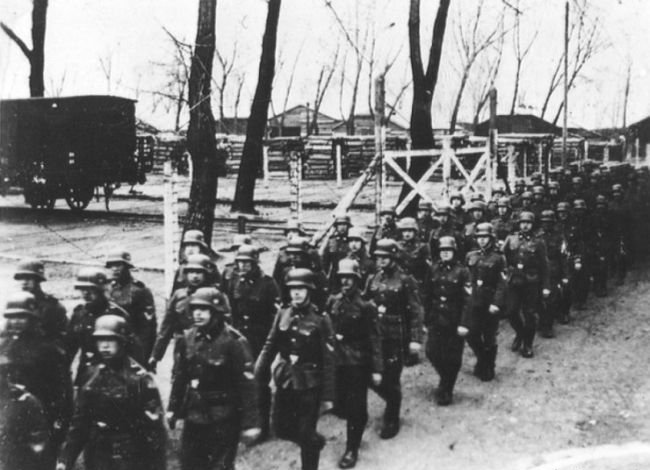 SS guards marching at the warehouse barracks ('Bauhof'), at Auschwitz I, Oswiecim, occupied Poland, 1941