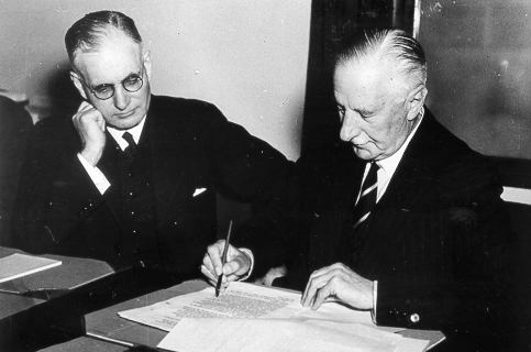 Governer General of Australia Lord Gowrie signing the declaration of war against Japan with Prime Minister John Curtin looking on, at 1115 hours, 8 Dec 1941 (2015 hours, 9 Dec 1941 local time)