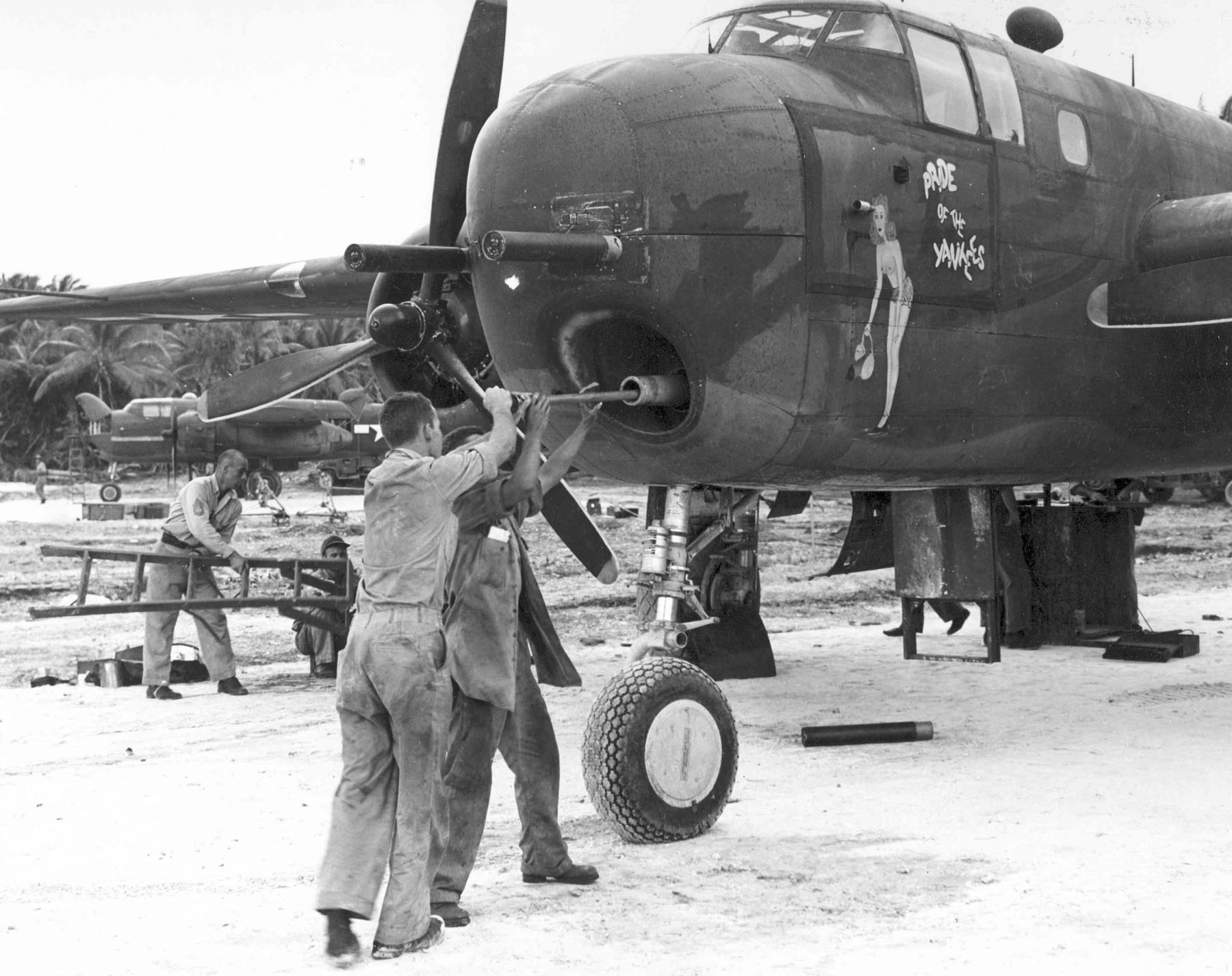 Armorer cleaning the bore of a 75mm cannon mounted in a B-25G Mitchell bomber of the 820th Bomb Squadron, Tarawa, Gilbert Islands; Mar-Apr 1944