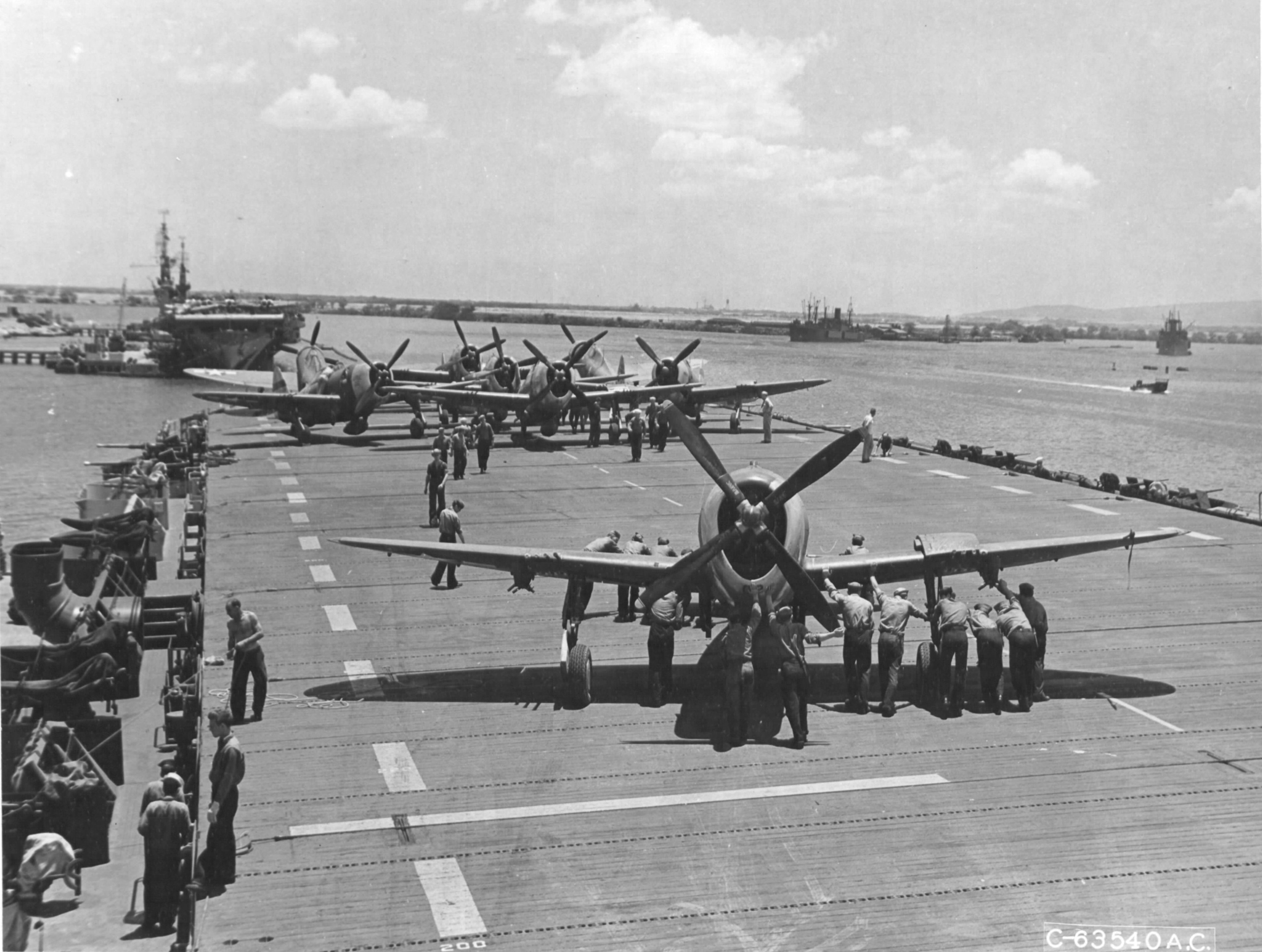 P-47D Thunderbolts of the 318th Fighter Group are loaded onto Escort Carrier USS Natoma Bay, Pearl Harbor, Hawaii, June 1, 1944. The Fighter Group was on its way to Saipan, Marianas. Note USS Manila Bay with the rest of the Fighter Group’s Thunderbolts.