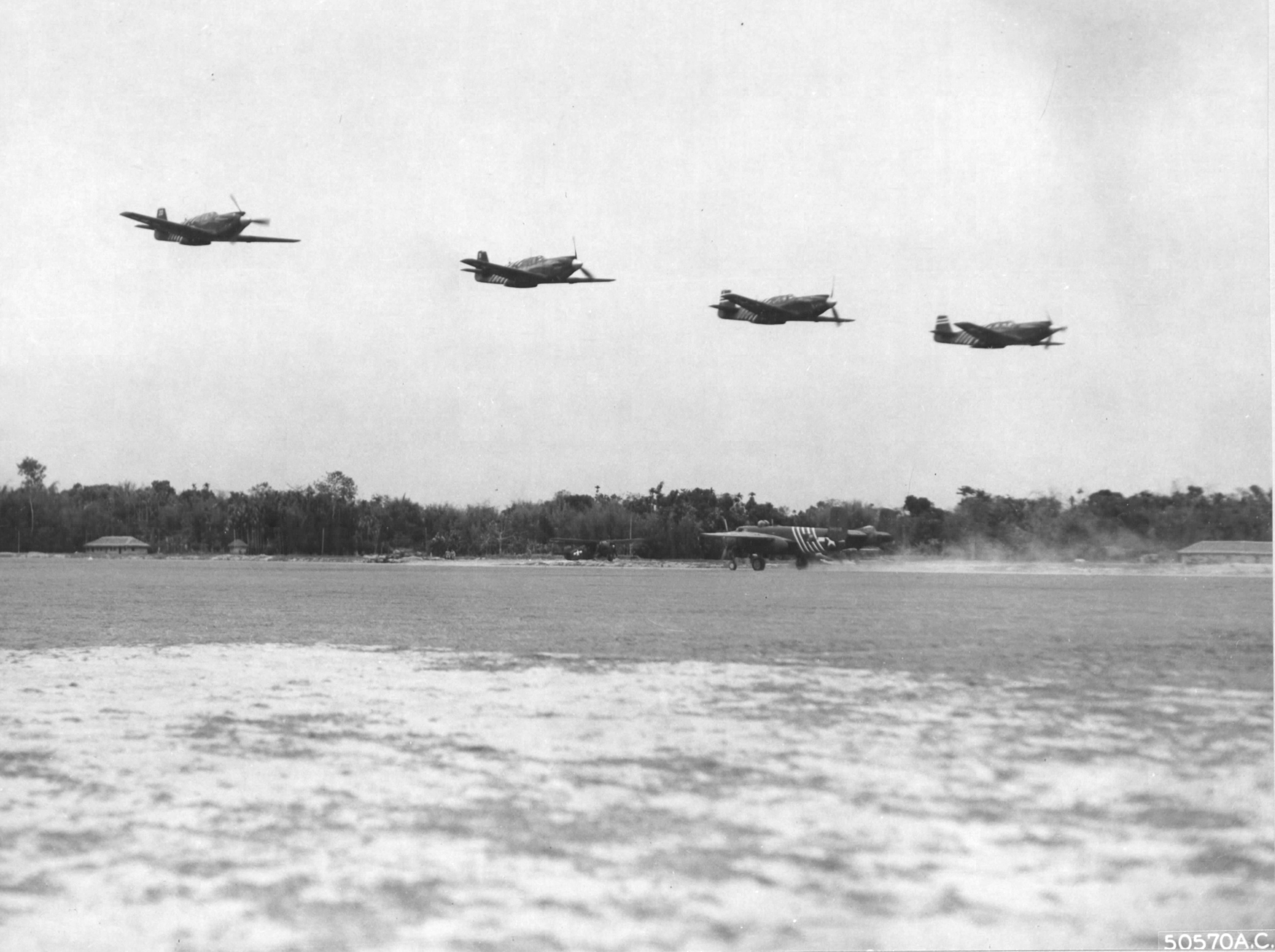 P-51A Mustangs do a low pass over a forward air field of the 1st Air Commandos, Burma, Apr 1944. Note also a B-25H Mitchell and an L-1 Vigilant