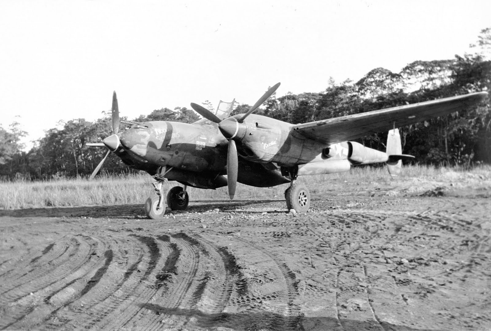 A P-38 Lightning with the 80th Fighter Squadron, the “Headhunters,” at rest at Dobodura, New Guinea, Dec 1943 – Feb 1944. Note the improvised wheel chocks.