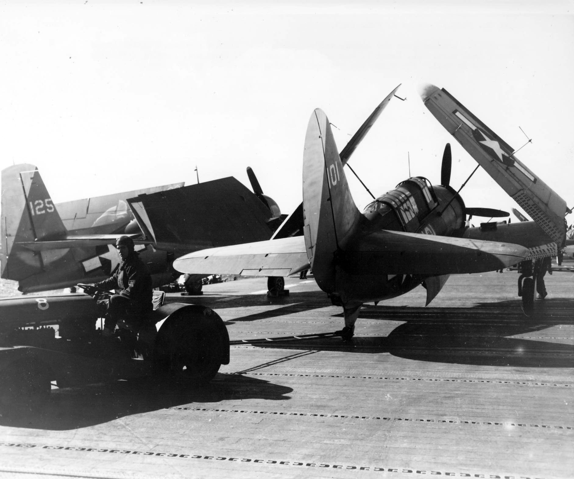 An aircraft tug moving an SB2C Helldiver into position on the flight deck of the carrier USS Yorktown (Essesx-class), 1945. Note TBM Avenger spotted on the deck.