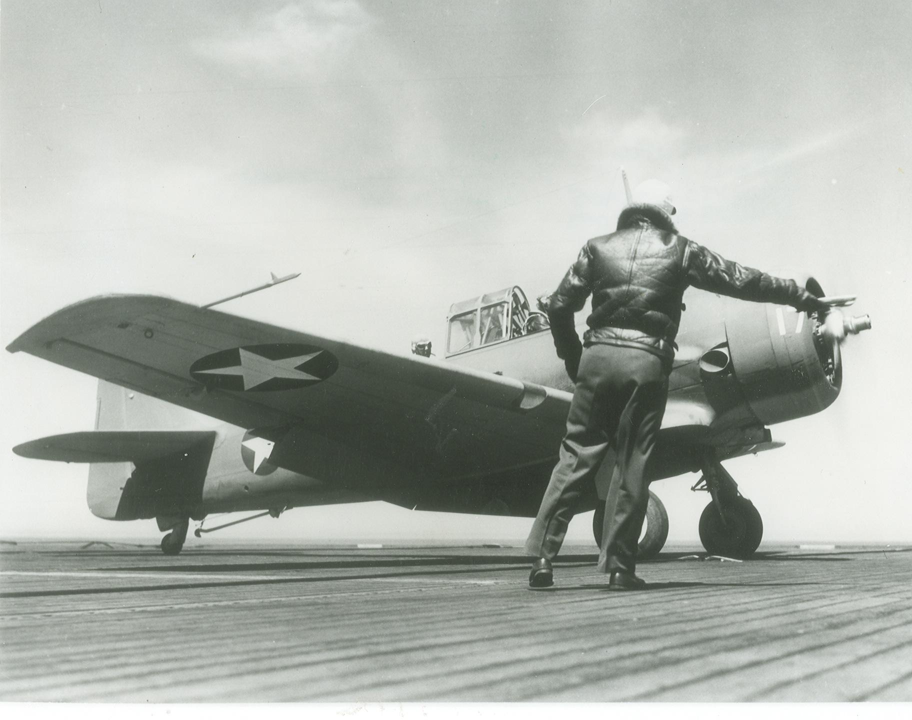 The Deck Officer gives an SNJ-3C Texan the go-ahead to launch from the training aircraft carrier USS Wolverine on Lake Michigan, United States, 26 Apr 1943.