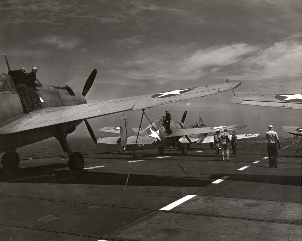 An SNJ Texan, an F4F Wildcat, and a TBF-1 Avenger tied down on the flight deck of the training aircraft carrier USS Wolverine on Lake Michigan, United States, 1943.