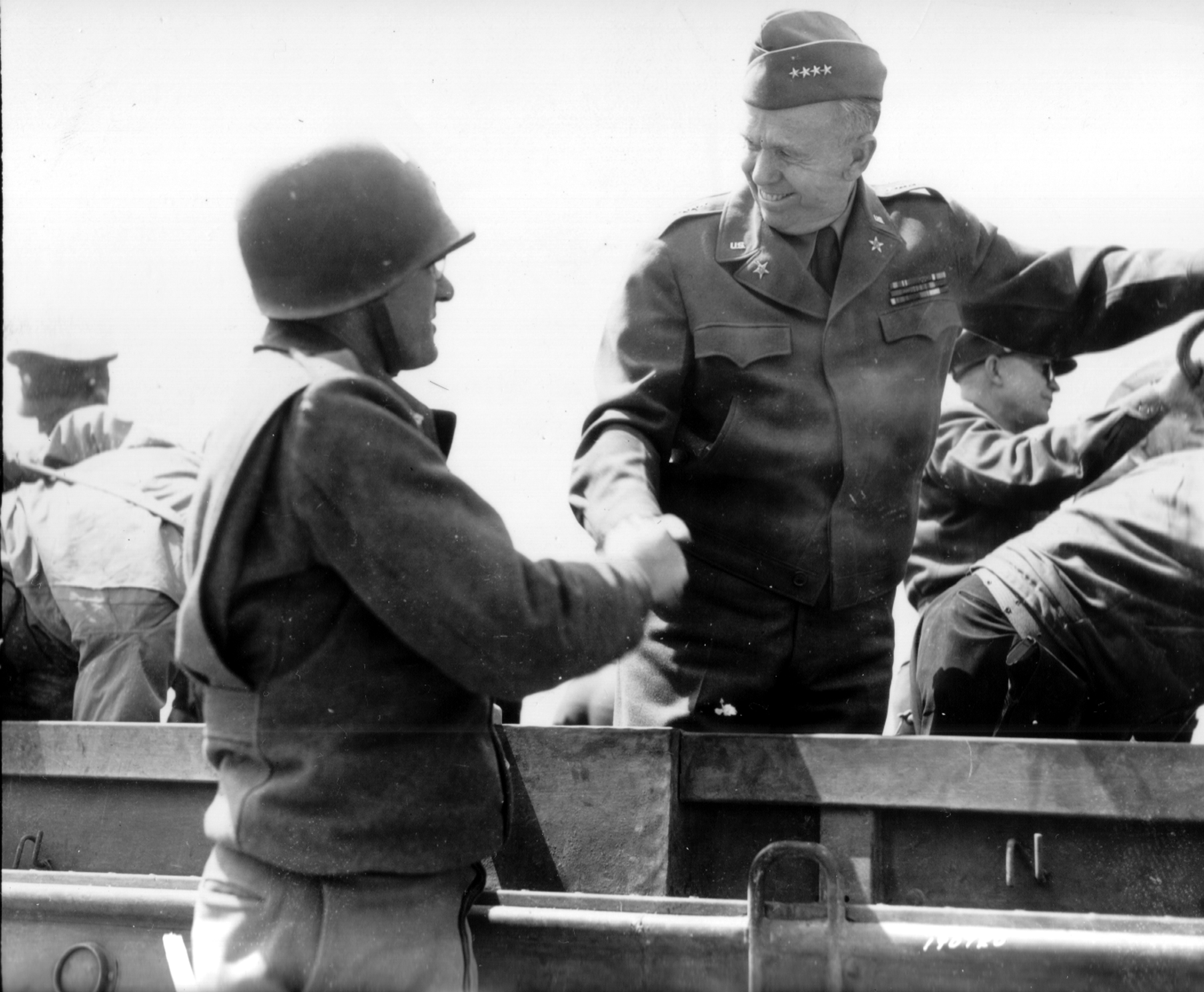 US Army Chief of Staff, Gen George Marshall shakes hands with another officer during his tour of the Normandy beachhead, Normandy, France, Jun 12, 1944.  Note Gen Eisenhower behind Marshall.