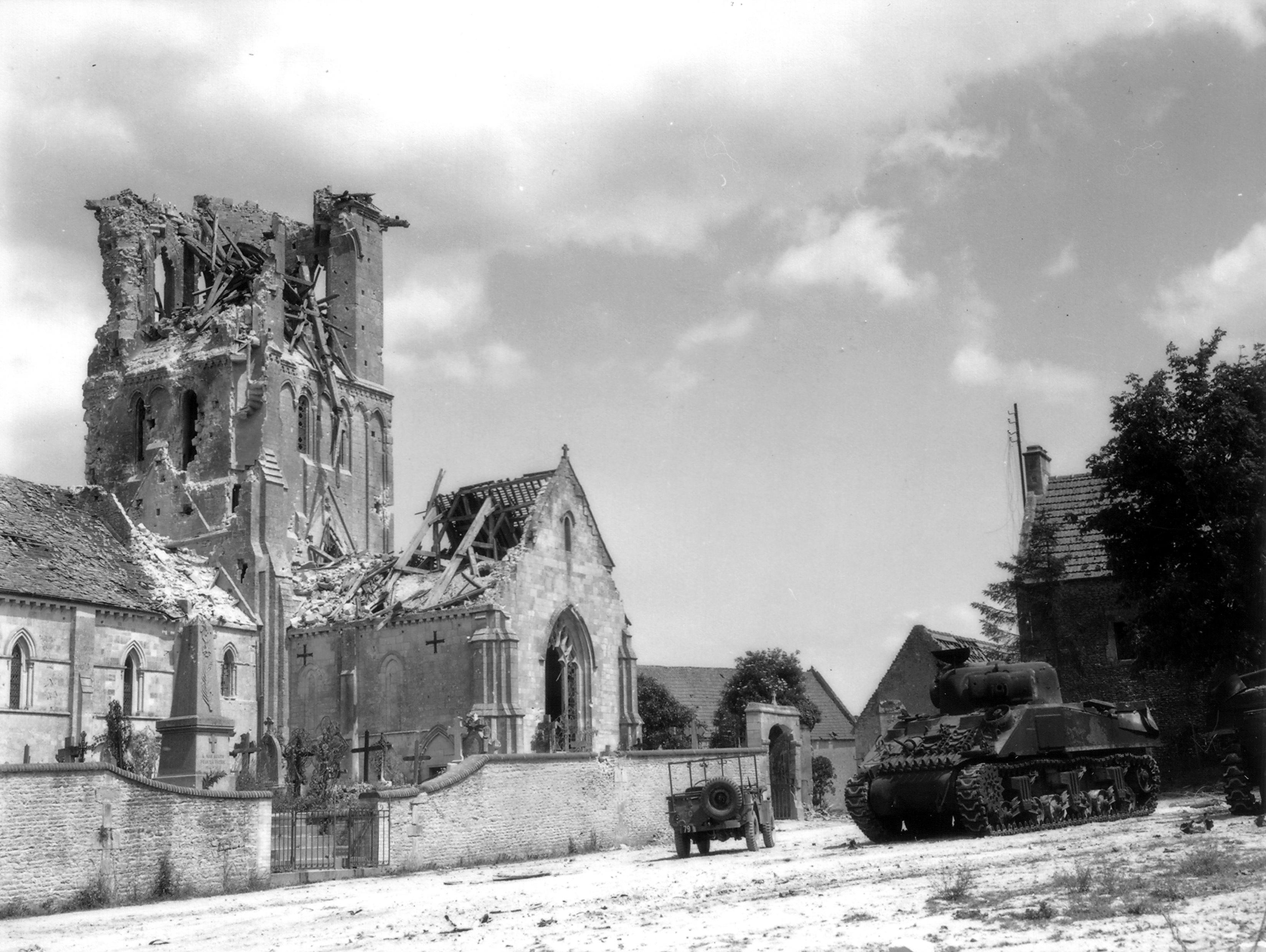 Two disabled M4 Sherman tanks and a litter Jeep near the heavily damaged Église Saint-Ouen in Rots, France (near Caen), Jun 11, 1944.