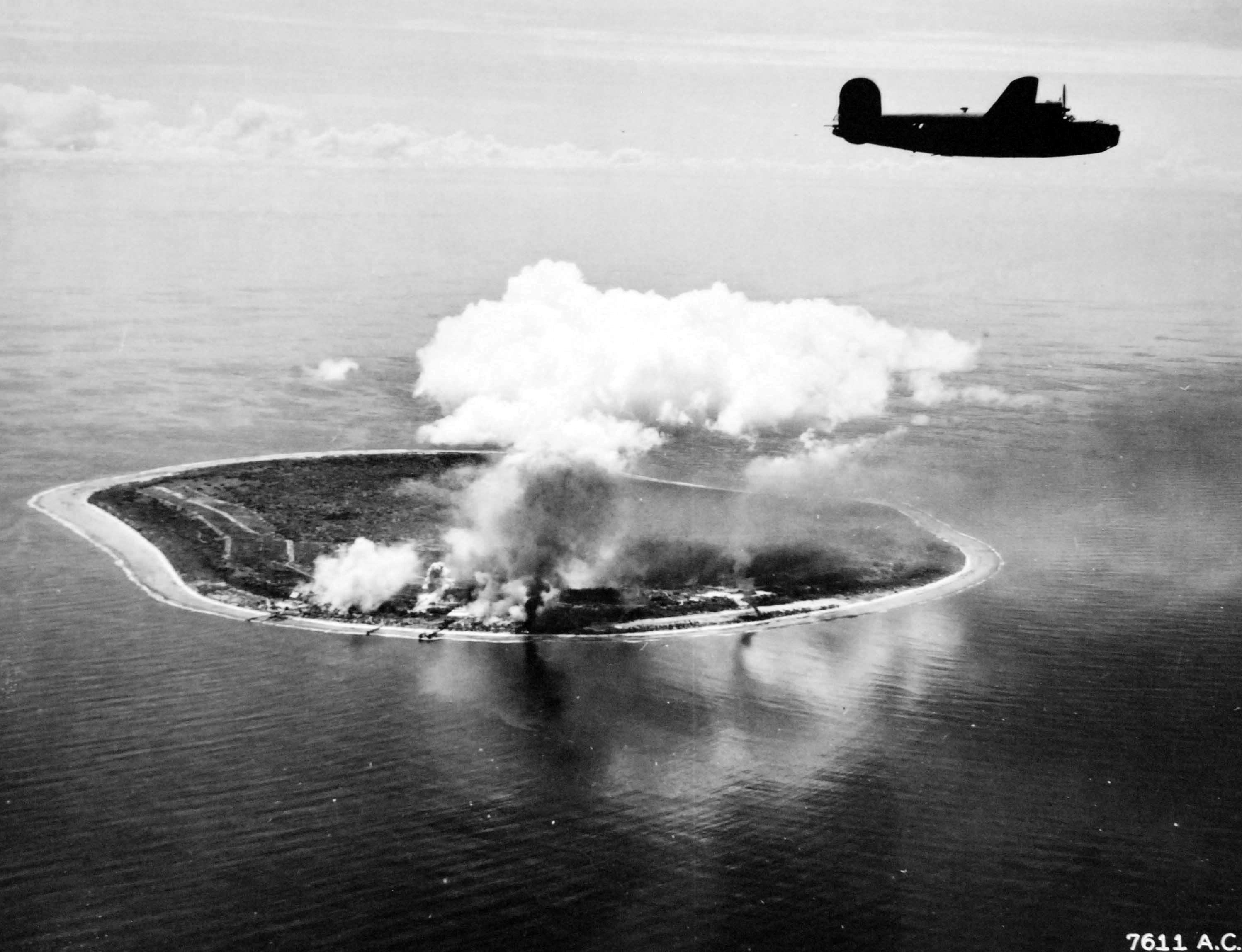 B-24 Liberator of the US 307th Bomb Group over the smoking airstrip on Nauru Island after being bombed, Apr 20, 1943.