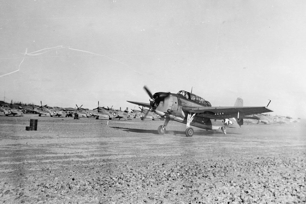 TBM-3 Avenger of Marine Squadron VMTB-242 taxiing past USAAF P-51D Mustangs at Iwo Jima's Motoyama Airfield No 1, 1945.