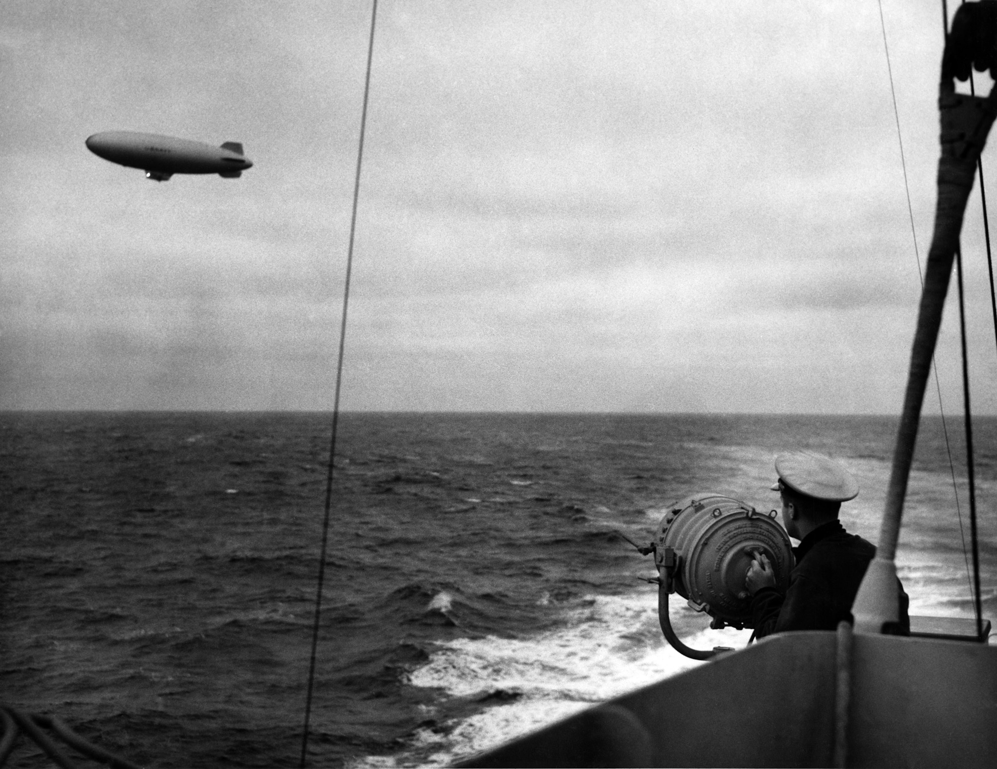 US Coast Guard Cutter Duane exchanging blinker signals with a US Navy K-class airship, 1943.  Both crafts were serving as convoy escorts in the North Atlantic.