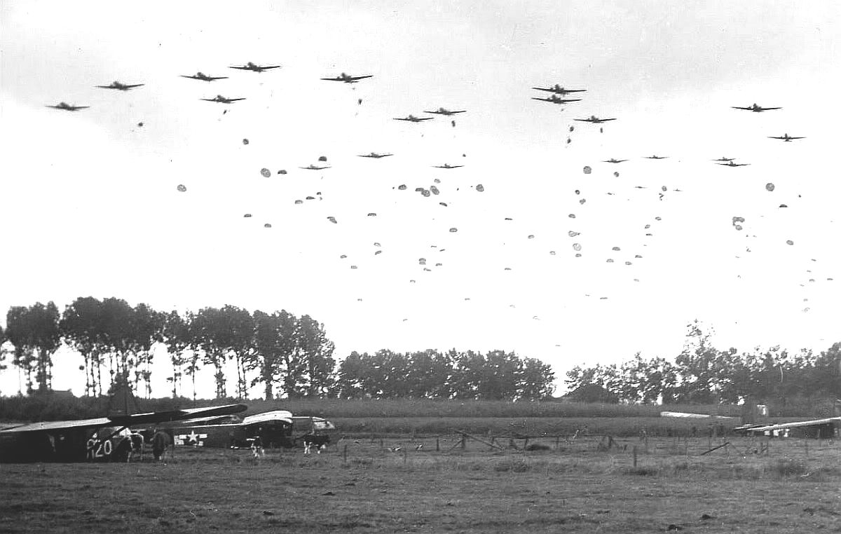 C-47 Skytrain aircraft of US 315th Troop Carrier Group dropping 41 sticks of 1st Polish Airborne Brigade into Grave, the Netherlands, 23 Sep 1944; note CG-4A gliders already on the ground. Photo 1 of 2.