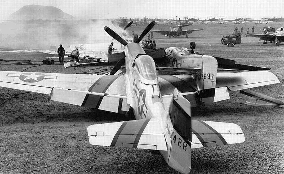 Two P-51D Mustangs of the 45th Fighter Squadron after a ground crash at South Field, Iwo Jima, June 1945. Note Mt Suribachi.