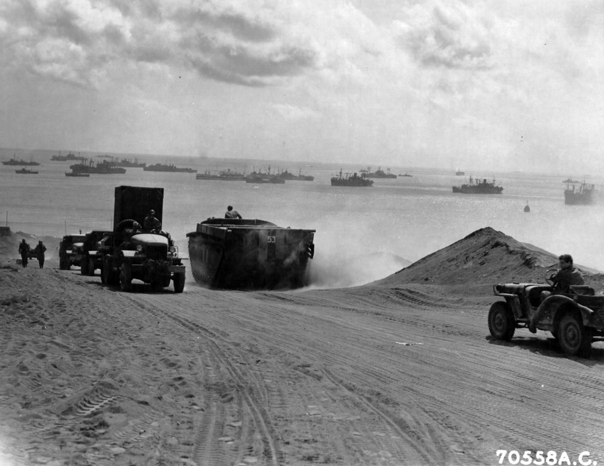 Columns of vehicles transferring supplies up from the beach on Iwo Jima, Mar 10, 1945.