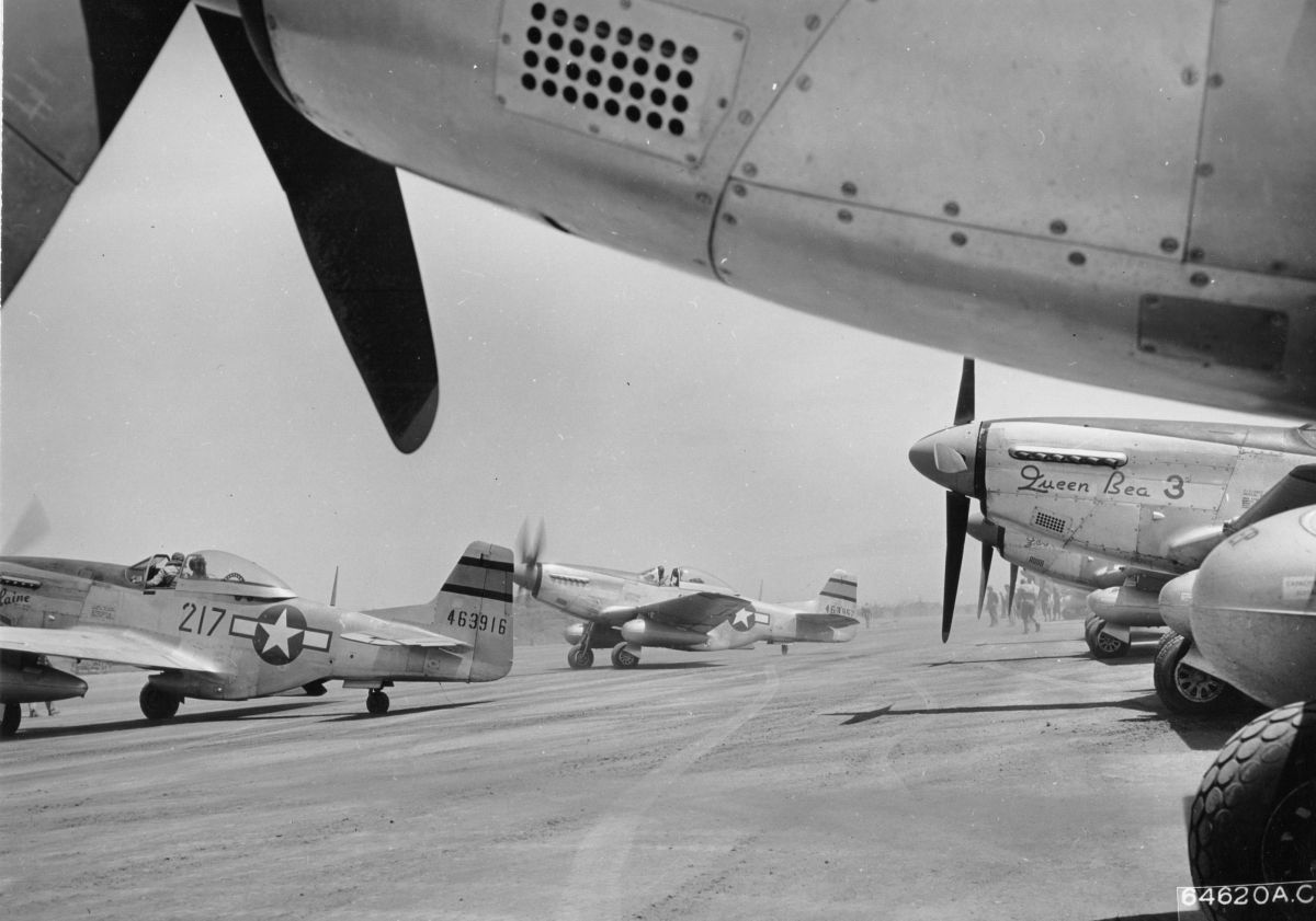 North American P-51D Mustangs of the 46th Fighter Squadron on Iwo Jima prepare for mission, Mar 1945. Note the twin oversized drop tanks of the Very Long Range (VLR) escorts.