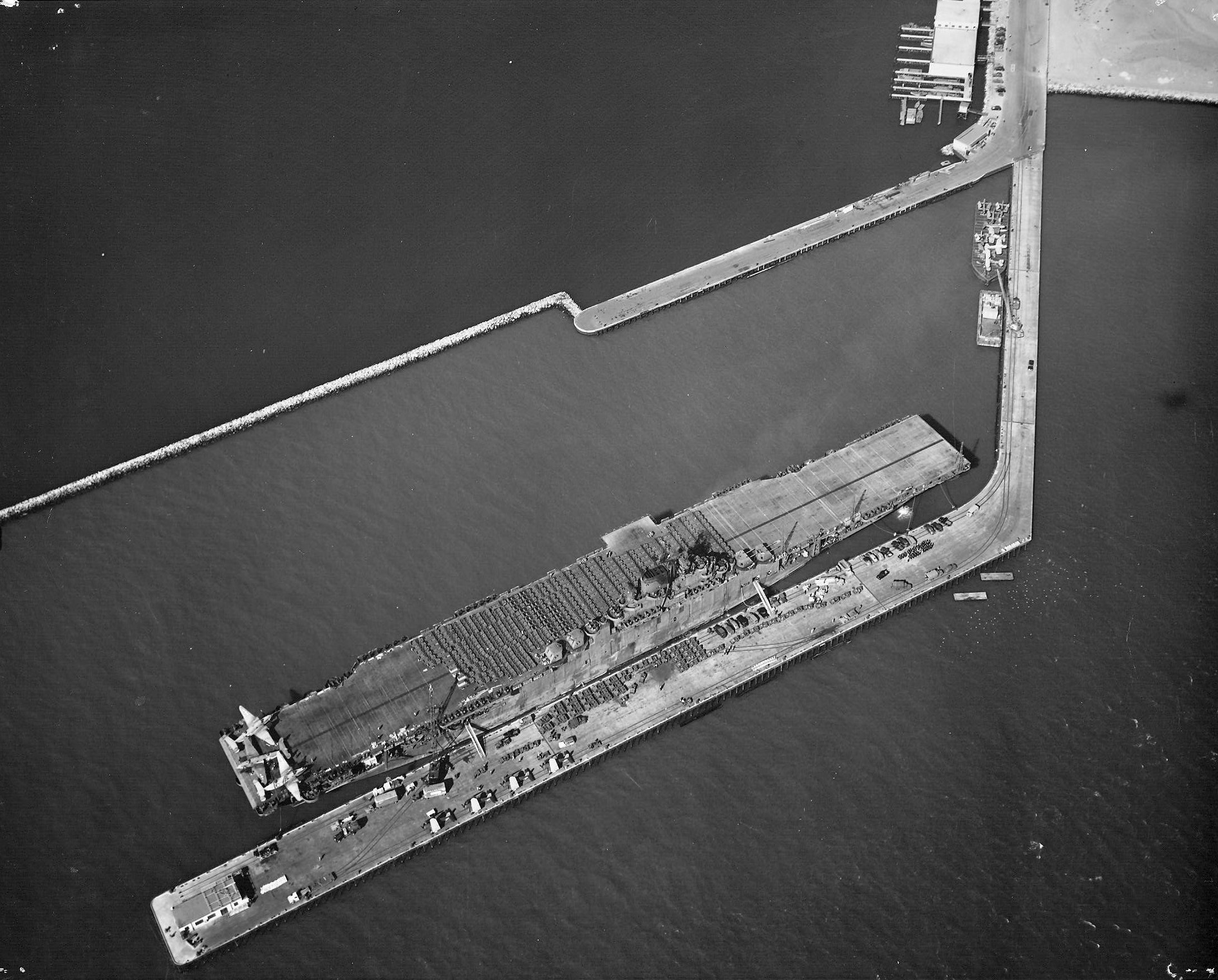 USS Yorktown (Essex-class) at the Alameda Naval Air Station loading aircraft and vehicles for transportation to the Pacific, 14 Sep 1943. Note three PV-1 Venturas on the after flight deck. Photo 2 of 2.