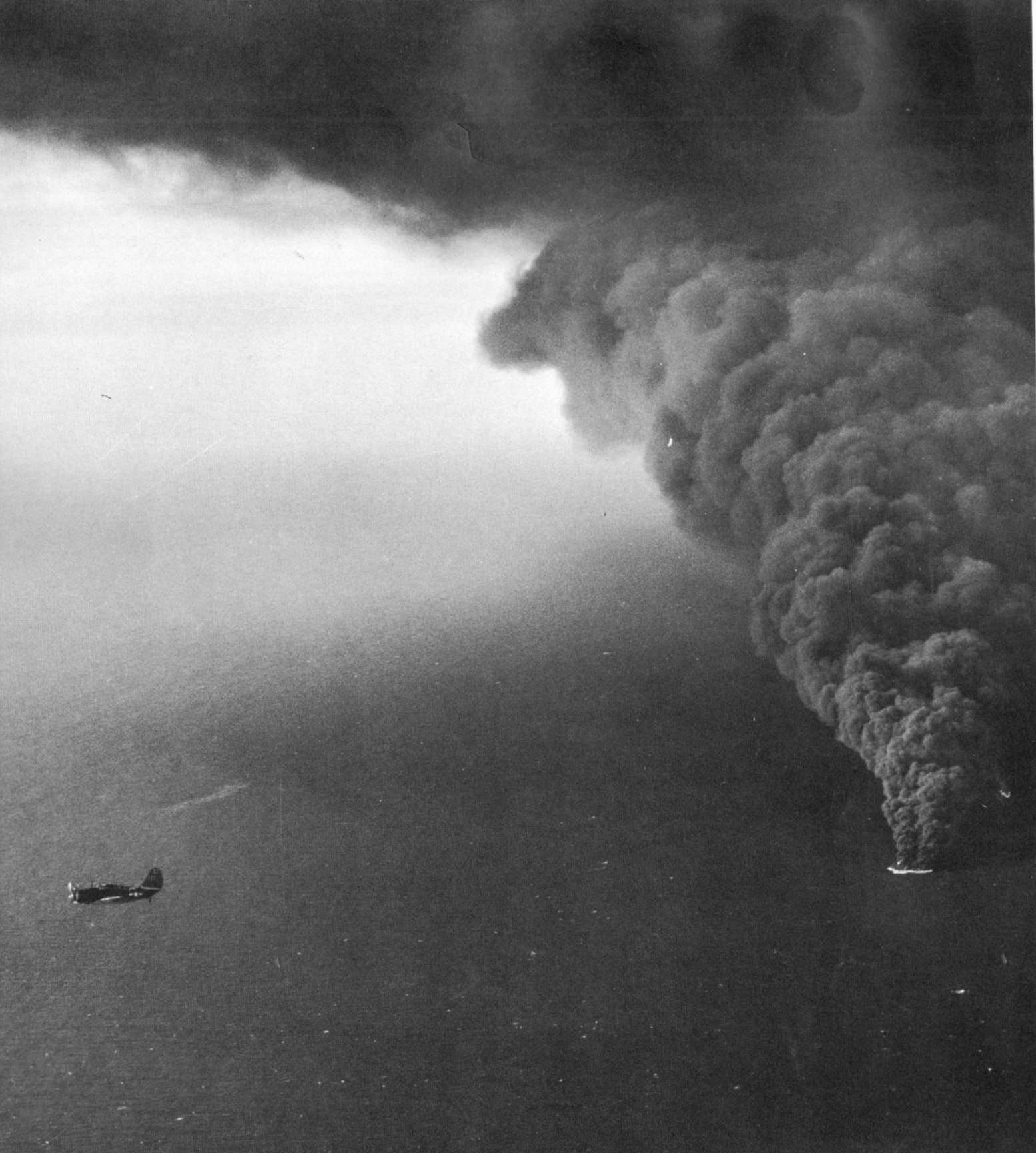 Strike photo of a Curtiss SB2C Helldiver from USS Hancock over burning Japanese merchant ships off French Indochina (Vietnam), 12 Jan 1945.