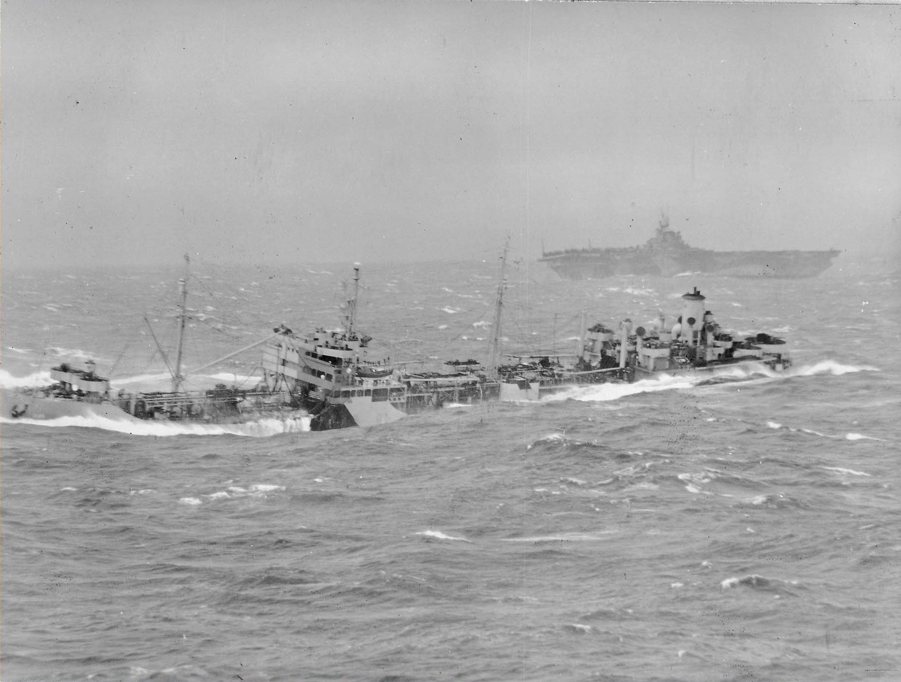 Photo from USS Essex showing Fleet Oiler USS Aucilla riding the rough seas that made refueling operations impossible, 13 Jan 1945. USS Ticonderoga is seen beyond.