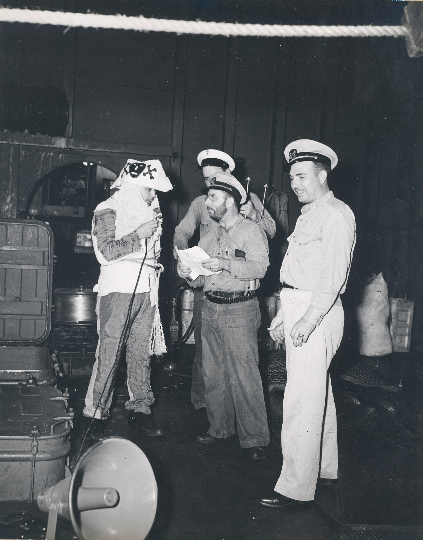 The Ruler of the Raging Main, Neptunus Rex, and his escort in the hangar deck of the USS Intrepid for the Line Crossing ceremonies, 22 Jan 1944.