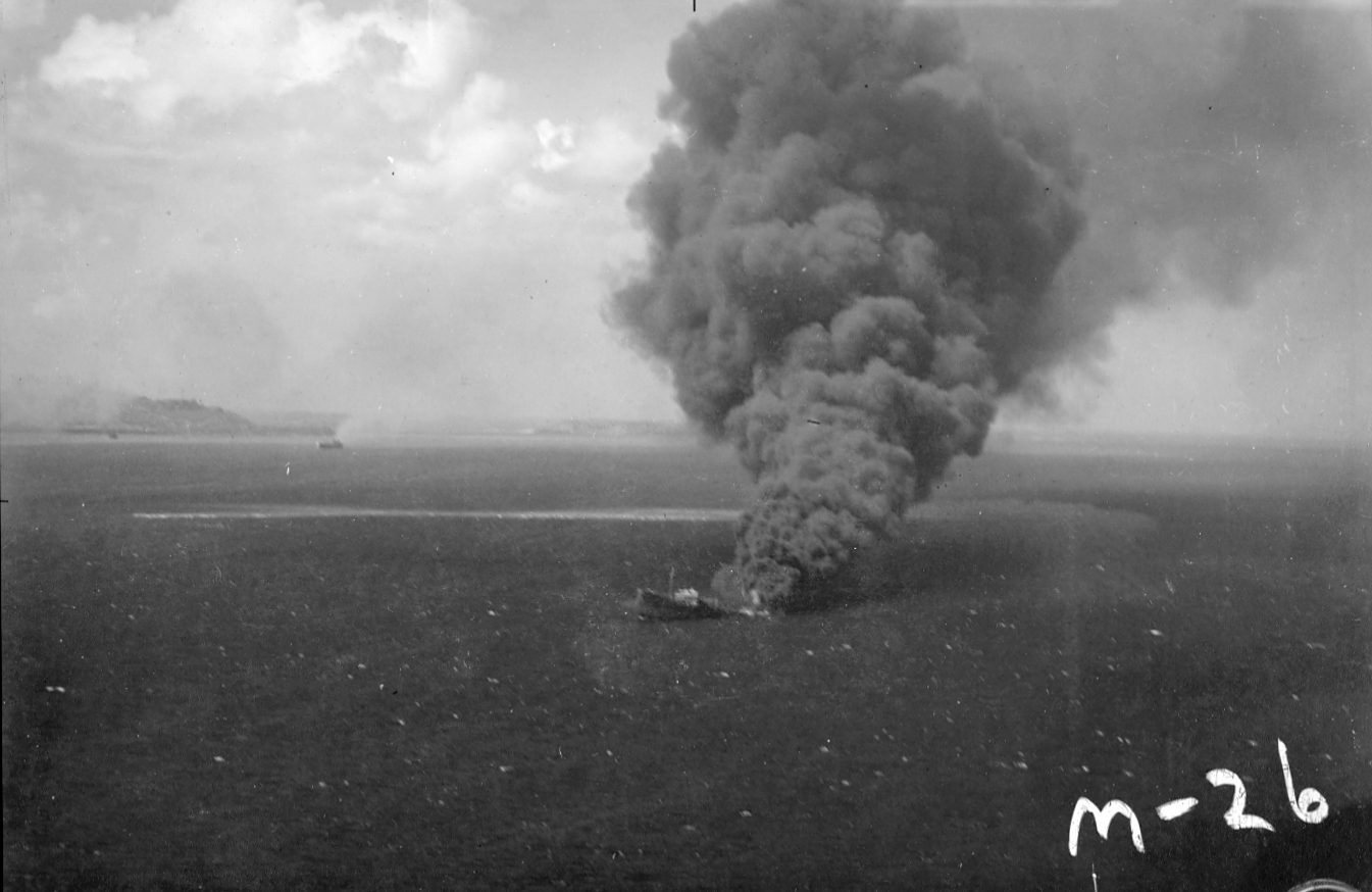 Strike photo taken by aircraft from USS Enterprise showing a burning and sinking oil tanker in the Truk Lagoon (now Chuuk), Caroline Islands, 16 Feb 1944.