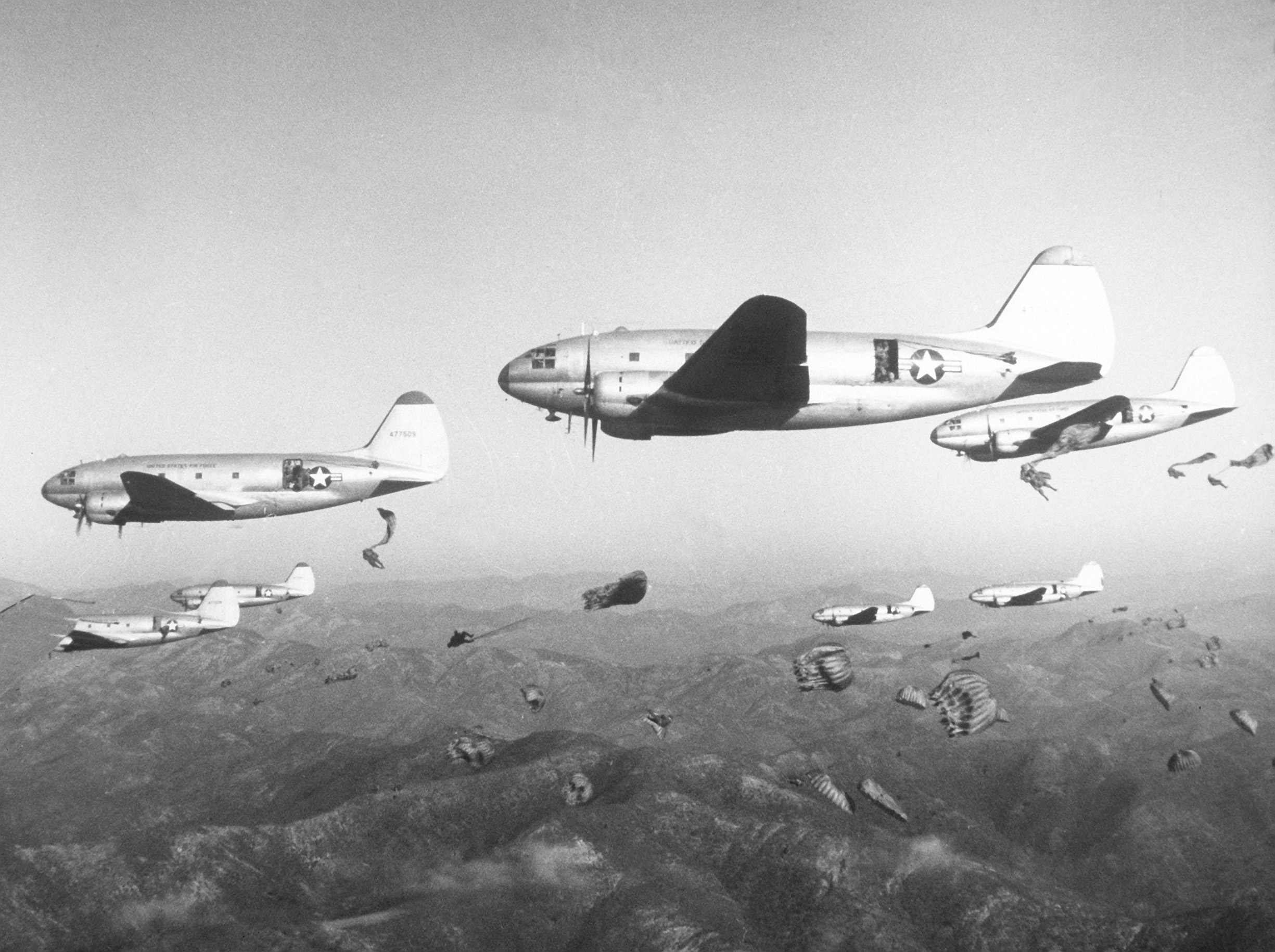 US 187th Regimental Combat Team troops being paradropped from C-46 transport aircraft during a training operation over Korea, date unknown